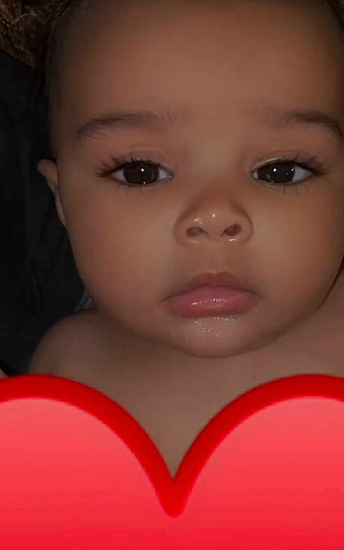 Srynity is registered to the contest to win money with this photo: baby, face, closeup, child, infant, eyes, expressionless, skin, portrait, young, cute, adorable, red_heart, emoji, indoors, head, lips, nose, eyelashes, human