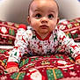 baby, infant, child, pajamas, reindeer, christmas, holiday, pattern, blanket, santa_claus, presents, festive, cute, indoors, crawling, face, expression, red, green, white