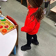 Ugo participe au concours pour gagner de l'argent avec cette photo : adult, black_pants, black_shoes, chair, child, clothing, education, feet, floor, fruit_puzzle, hair, indoor, learning, person, playroom, puzzle, red_jacket, table, toddler, toy