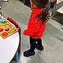 adult, black_pants, black_shoes, chair, child, clothing, education, feet, floor, fruit_puzzle, hair, indoor, learning, person, playroom, puzzle, red_jacket, table, toddler, toy