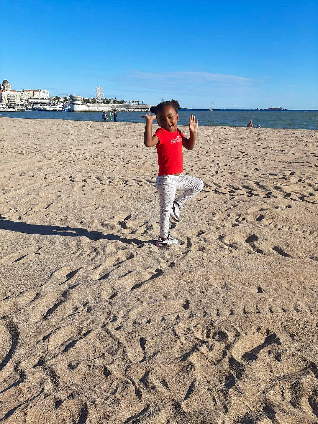 Mariem a rejoint le concours — aidez-le/la à gagner de superbes lots ! azure, beach, body_of_water, cloud, coastal_and_oceanic_landforms, ecoregion, fun, gesture, happy, horizon, jeans, joy, landscape, leg, morning, natural_environment, people_in_nature, people_on_beach, person, sky