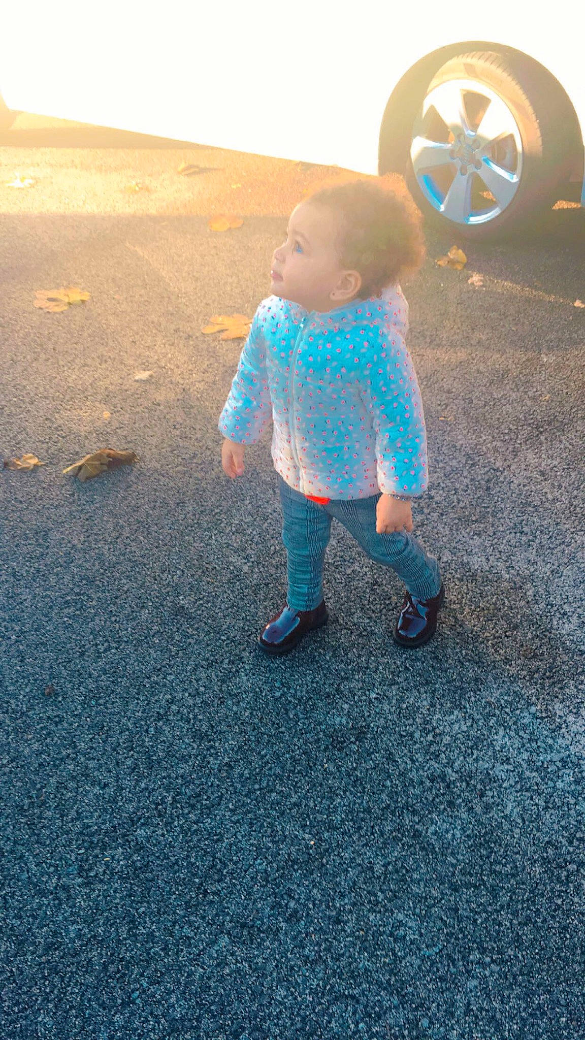 Kenza participe au concours pour gagner de l'argent avec cette photo : asphalt, automotive_lighting, automotive_tire, child, electric_blue, flooring, fun, grass, leg, leisure, people_in_nature, person, recreation, road, road_surface, sky, standing, tints_and_shades, toddler, vehicle_door