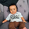 baby, child, curly_hair, white_shirt, brown_pants, feet, armchair, tufted_chair, indoor, person, cute, sitting, portrait, face, expression, clothing, furniture, skin, infant, looking