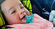 Theo is registered to the contest to win money with this photo: baby, pacifier, pink_bib, car_seat, blanket, smiling, child, indoors, car_interior, man, window, daylight, happy, portrait, cute, seatbelt, clothing, striped_shirt, head, face