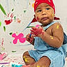 toddler, child, paint, colorful, bandana, denim_overalls, sitting, face_paint, feet, hands, playful, art, messy, indoor, baby, expression, skin, background, floor, bottle