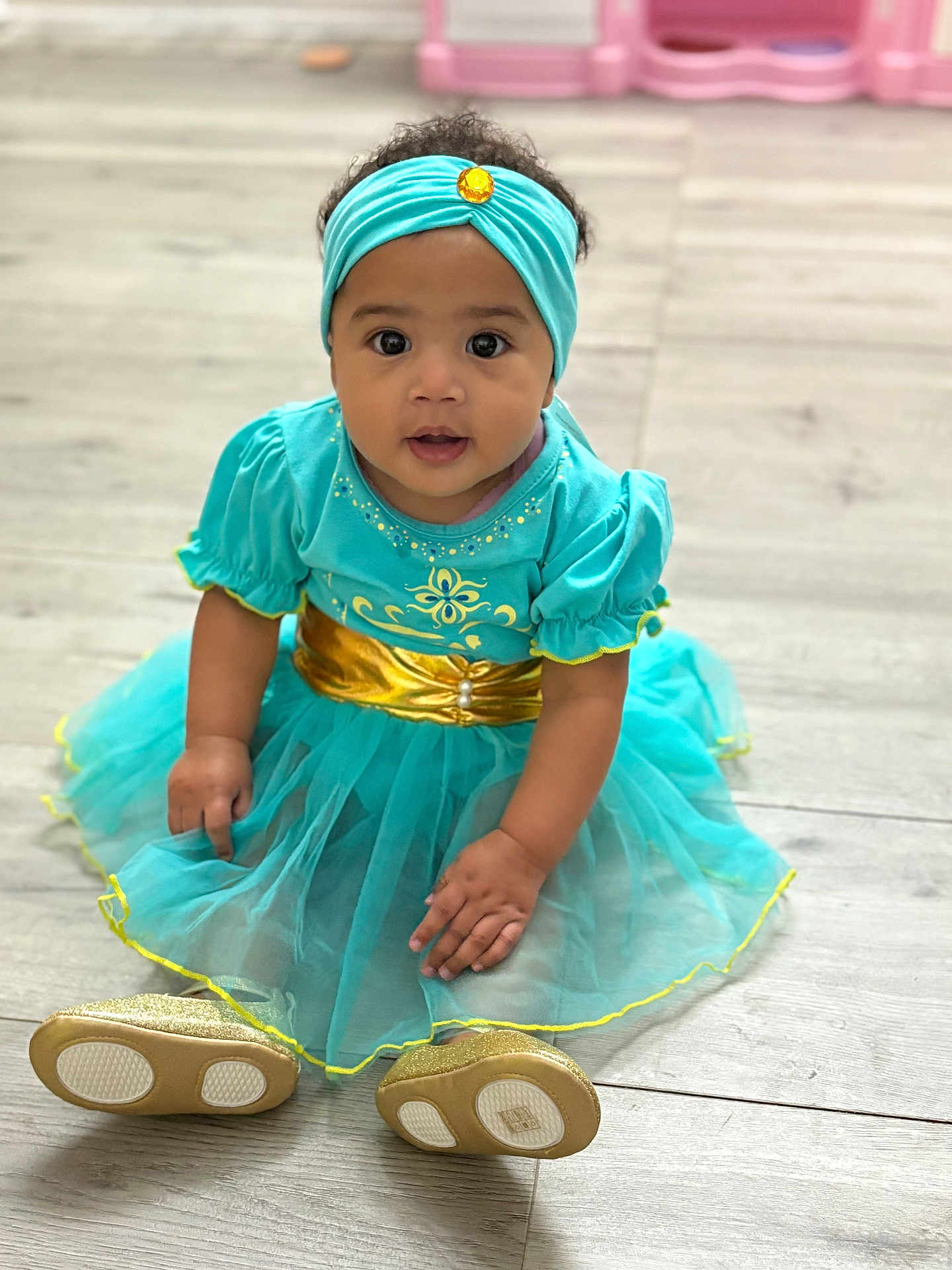 Anylah Brinson is registered to the contest to win money with this photo: baby, child, toddler, sitting, dress, headband, gold, turquoise, floor, curly_hair, indoors, cute, portrait, looking_at_camera, small_shoes, hand, skin, young, fashion, happy