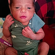 Tyquan joined the competition — help win amazing prizes! baby, background, black, blue, closeup, fabric, face, foot, green_onesie, hand, human, infant, legs, newborn, person, plaid, portrait, red, skin, tattoo