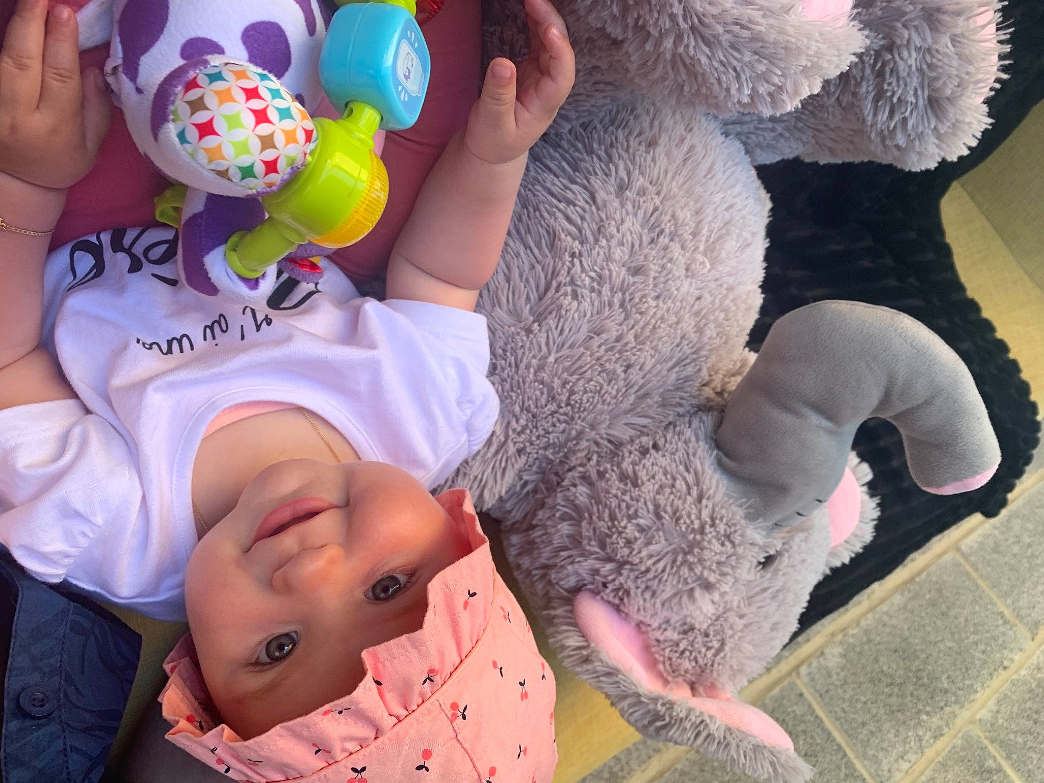 élie participe au concours pour gagner de l'argent avec cette photo : arm, child, finger, gesture, hand, happy, headwear, human_body, interaction, joy, mammal, organ, people, person, photograph, pink, product, textile, toddler, toy