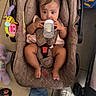 baby, infant, child, car_seat, bottle, feeding, sitting, portrait, face, eyes, hair_bows, pink_clothing, toy, colorful_toy, indoor, tile_floor, family, safe, candid, photography