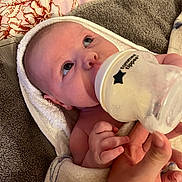 Lottie is registered to the contest to win money with this photo: baby, bottle, feeding, towel, hand, blanket, infant, newborn, skin, face, eyes, nurturing, comfort, closeup, child, person, soft, cozy, indoor, care