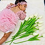 baby, child, cute, decorative, floral, green_stems, headband, indoors, infant, lace, lying_down, newborn, pink_outfit, portrait, side_view, soft_texture, tulips, tutu, white_blanket, white_flowers