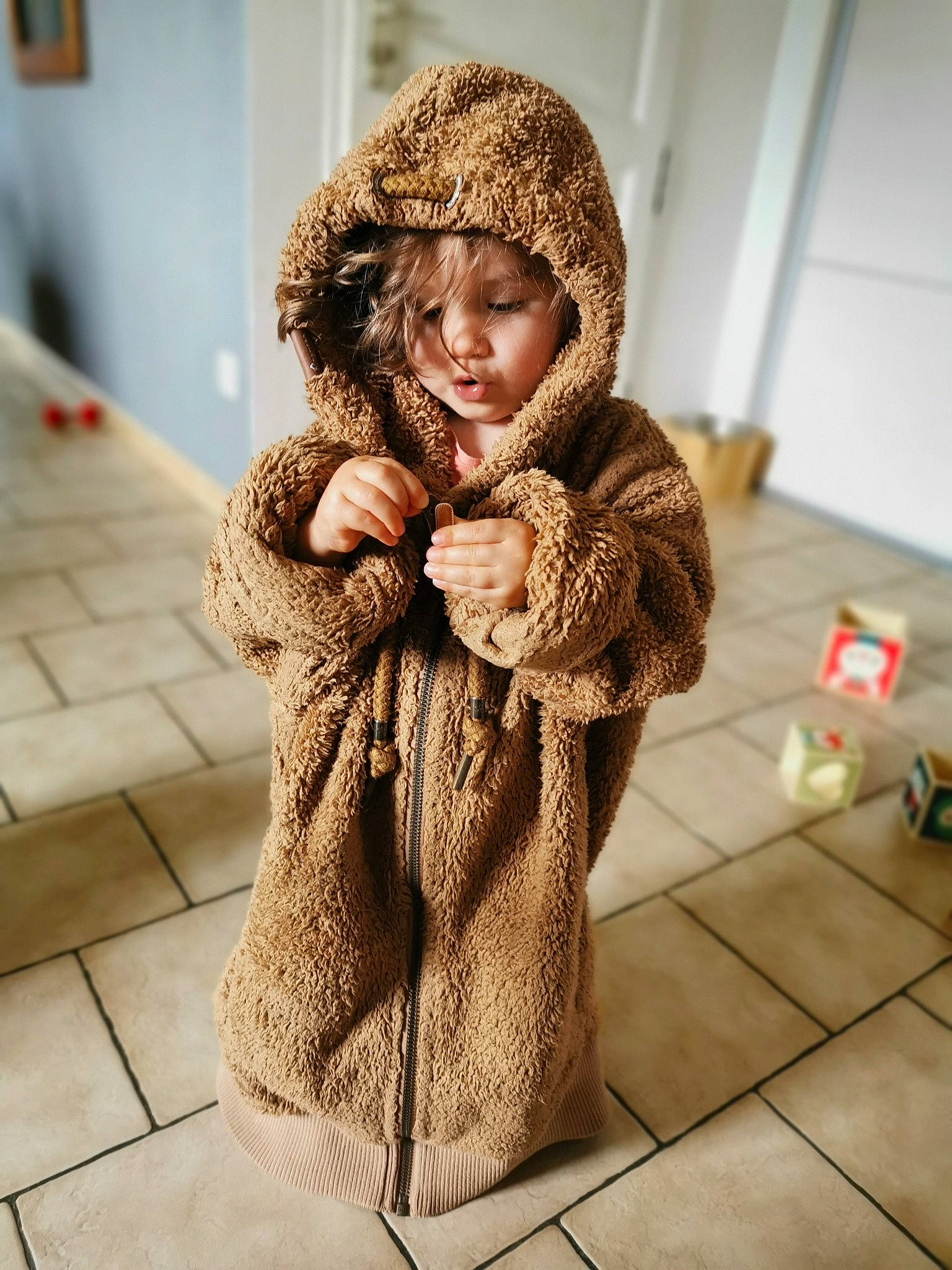Léane a rejoint le concours — aidez-le/la à gagner de superbes lots ! beige, brown_hair, cap, child, clothing, coat, fawn, fun, fur, fur_clothing, headgear, hood, jacket, natural_material, outerwear, parka, person, skin, textile, wool