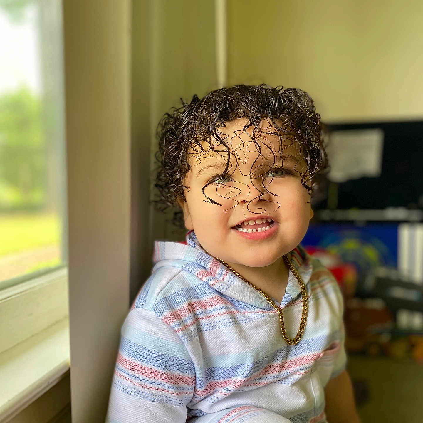 Carlisle is registered to the contest to win money with this photo: accessories, baby, blonde, bodypart, clothing, curlyhair, face, hair, happy, head, jewelry, mouth, necklace, person, photography, portrait, sleeve, smile, teeth, window