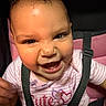 baby, child, smiling, happy, car_seat, seatbelt, pink_clothing, striped_shirt, face, infant, cute, messy, portrait, young_child, indoors, closeup, person, expressive, playful, seat