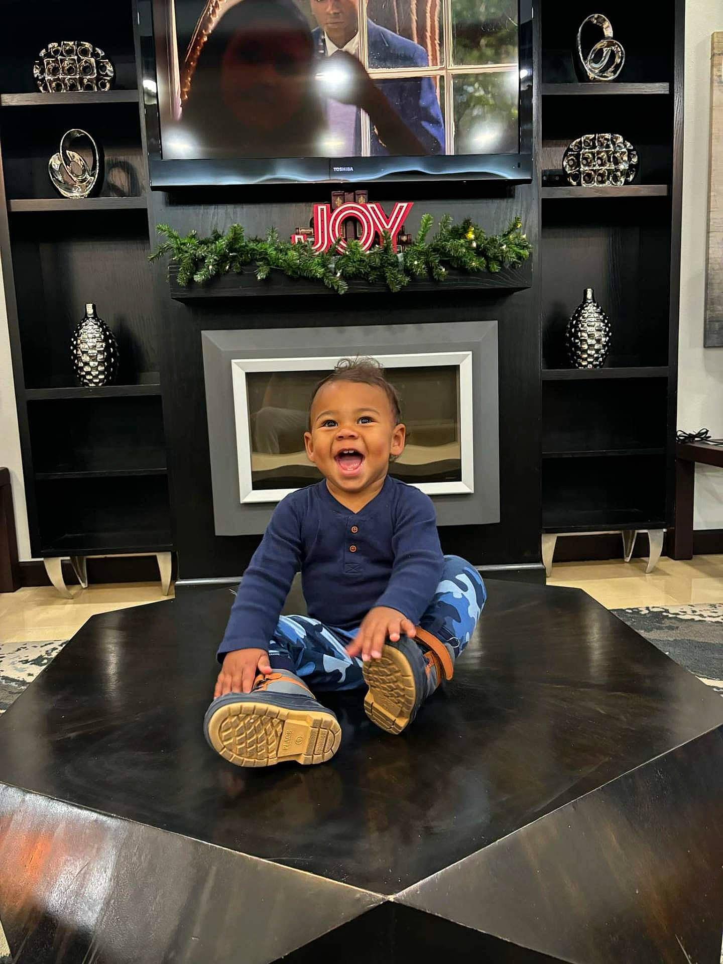 Illya is registered to the contest to win money with this photo: adult, boy, child, clothing, face, footwear, happy, head, indoors, jeans, male, man, pants, person, photography, plant, portrait, pottedplant, shoe, sitting