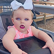 Ava Grace joined the competition — help win amazing prizes! toddler, child, stroller, outdoor, bow, pink_dress, vampire_filter, face, purple_eyes, fangs, lipstick, hands, seat, trees, fence, cars, daylight, playful, cute, baby