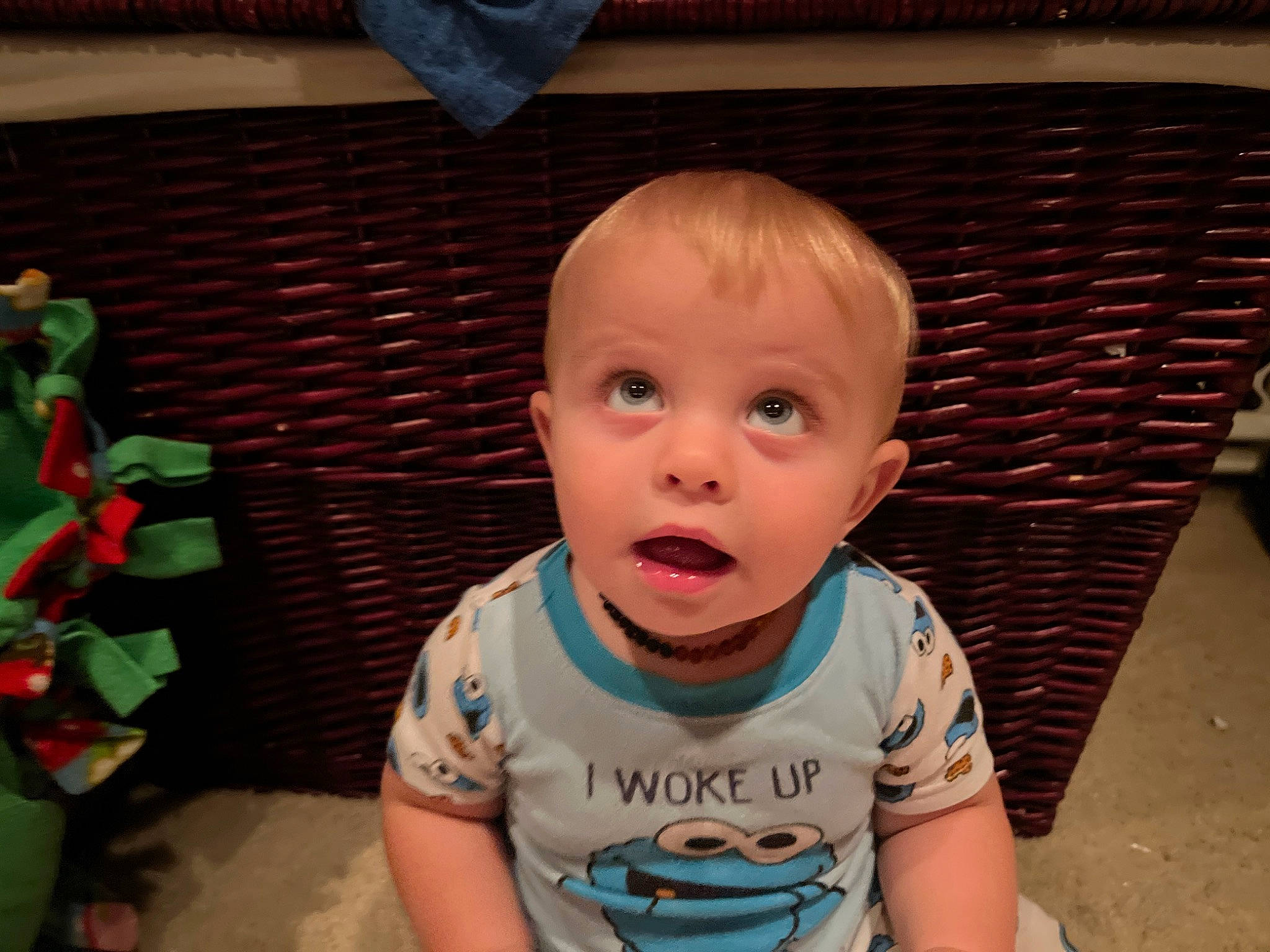 Jacob is registered to the contest to win money with this photo: baby, baby_toddler_clothing, cheek, child, eyelash, flooring, fun, green, happy, mouth, nose, person, room, sitting, skin, sleeve, stuffed_toy, surprise, t_shirt, toddler