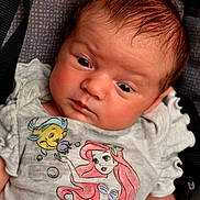 Gianna joined the competition — help win amazing prizes! baby, infant, child, face, expression, clothing, tshirt, cartoon, disney, ariel, flounder, portrait, closeup, person, cute, young, skin, hair, sitting, indoors