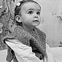 toddler, child, portrait, black_and_white, knitted_vest, hair_clip, curious, sitting, soft_light, indoors, long_sleeve, young_child, face, expression, cute, cozy, closeup, baby, person, innocence