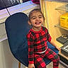Eliannie is registered to the contest to win money with this photo: blue_chair, box, cabinet, cable, checkered_pattern, child, crocs, curtain, face, footwear, happy, indoor, person, red_pajamas, shelf, sitting, smiling, toddler, window, wooden_floor