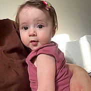 Ceylin participe au concours pour gagner de l'argent avec cette photo : baby, child, infant, person, face, hair_clip, pink_clothing, sitting, indoor, natural_light, adult_hand, curious_expression, close_up, portrait, casual, skin, young, cute, looking_at_camera, soft_light