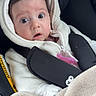 baby, child, car_seat, blanket, hooded_jacket, straps, wide_eyes, curious, infant, soft_fabric, pink_pacifier, indoors, seatbelt, warm_clothing, closeup, face, person, portrait, expression, cute