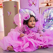 Thiya joined the competition — help win amazing prizes! baby, child, pink_dress, butterfly_wings, balloons, party, celebration, smiling, floor, decorations, headpiece, curly_hair, indoor, cute, festive, happy, toddler, colorful, portrait, sparkles