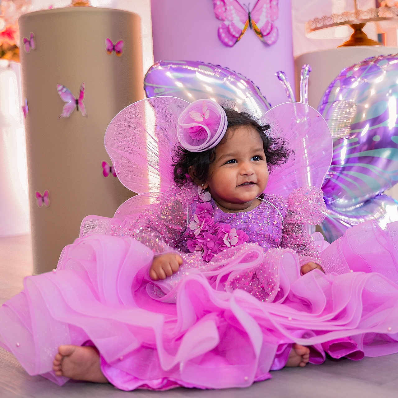Thiya joined the competition — help win amazing prizes! baby, child, pink_dress, butterfly_wings, balloons, party, celebration, smiling, floor, decorations, headpiece, curly_hair, indoor, cute, festive, happy, toddler, colorful, portrait, sparkles