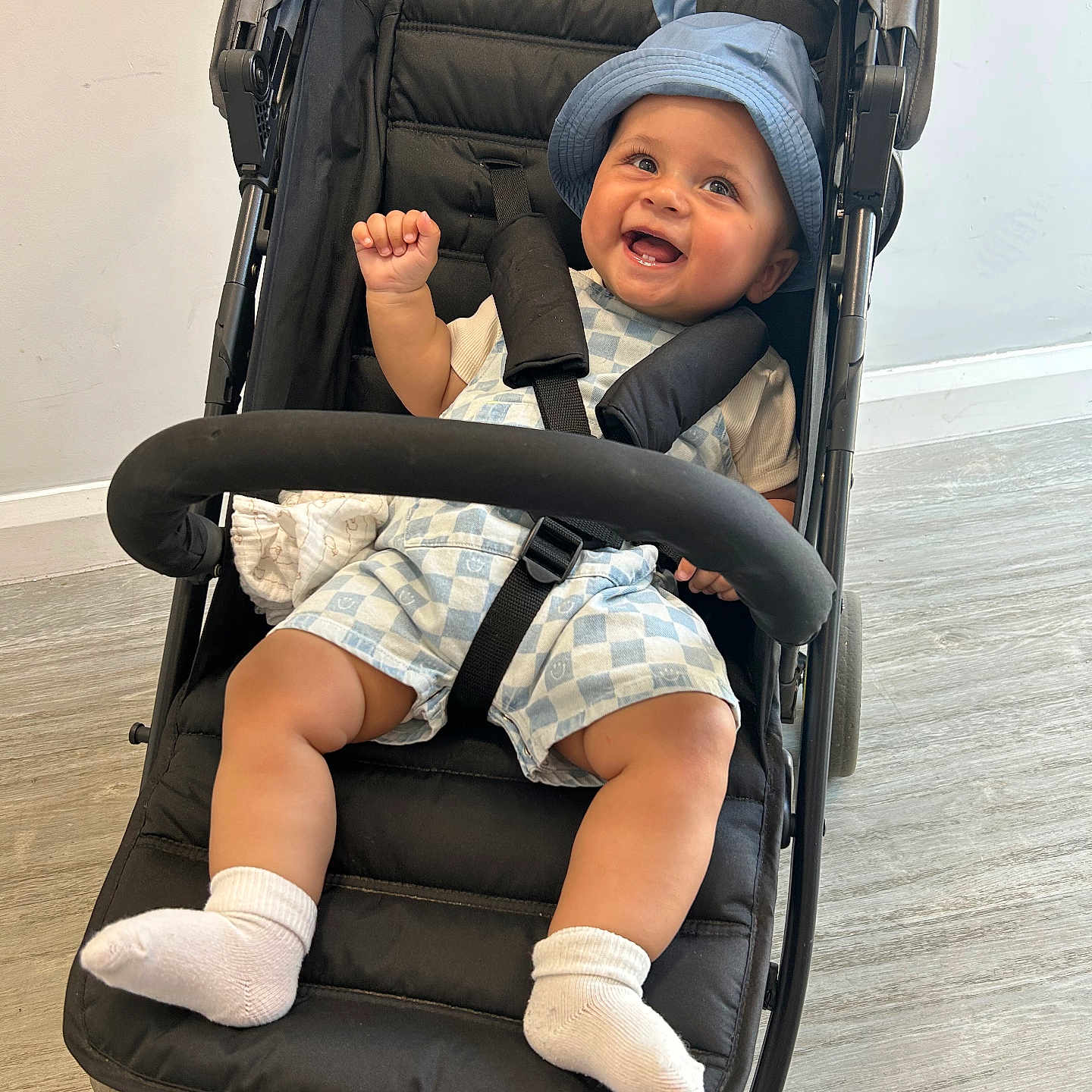 Hunter is registered to the contest to win money with this photo: baby, babylaughing, clothing, face, happy, hat, head, hosiery, person, photography, portrait, shorts, smile, sock, stroller