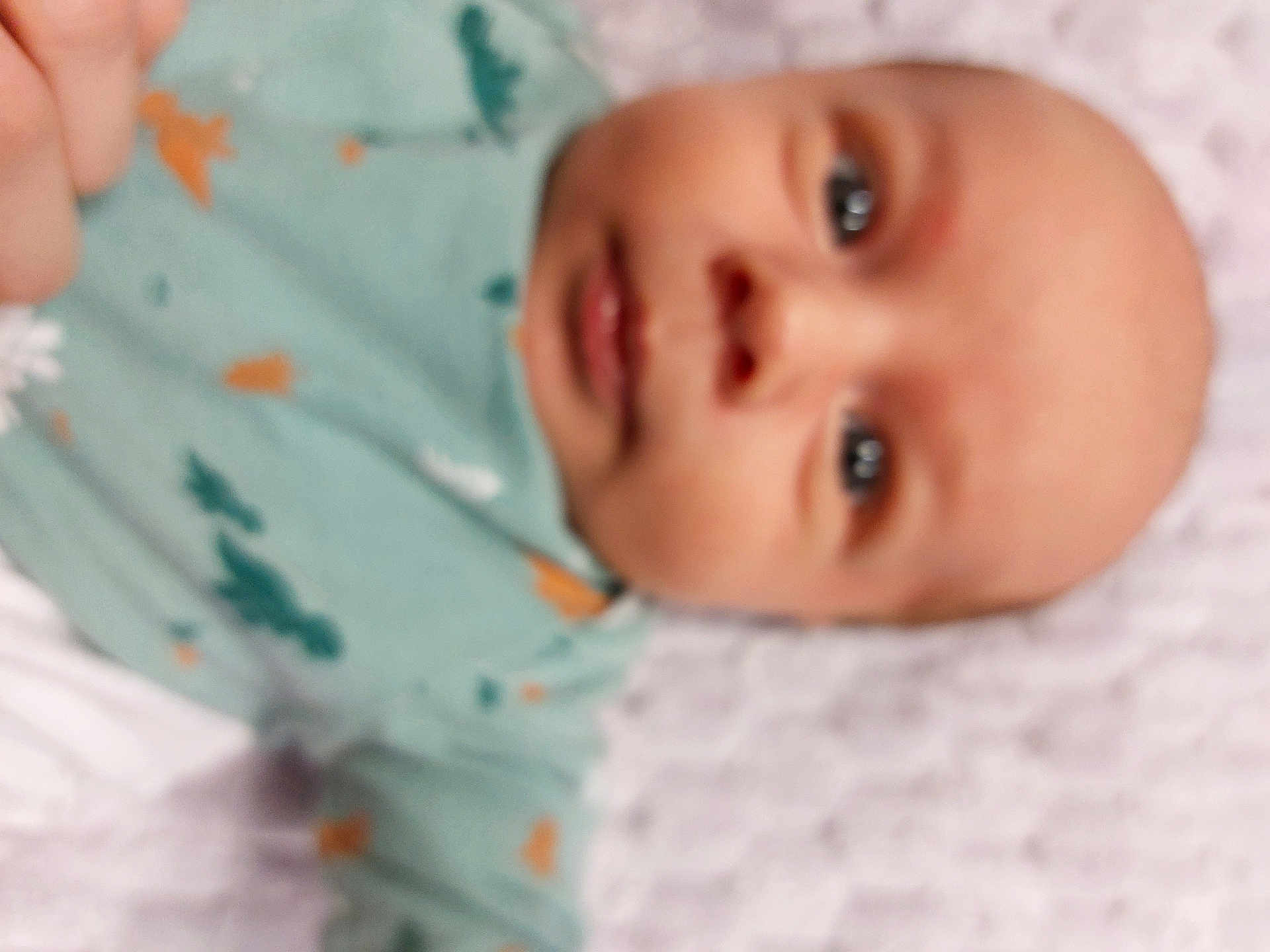 Mathias ștefan participe au concours pour gagner de l'argent avec cette photo : baby, infant, face, blur, closeup, child, clothing, green_outfit, pattern, lying_down, skin, head, eyes, mouth, newborn, person, indoors, soft_focus, young, human