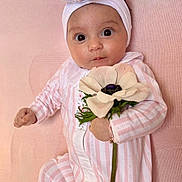Naël a rejoint le concours — aidez-le/la à gagner de superbes lots ! baby, infant, flower, headband, pink, striped_clothing, blanket, cute, portrait, child, young, laying_down, soft_texture, adorable, closeup, big_eyes, hand, white_flower, headwear, sleepwear