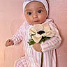 baby, infant, flower, headband, pink, striped_clothing, blanket, cute, portrait, child, young, laying_down, soft_texture, adorable, closeup, big_eyes, hand, white_flower, headwear, sleepwear