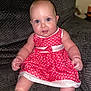 Isabelle is registered to the contest to win money with this photo: baby, bodypart, clothing, couch, cushion, dress, face, finger, furniture, hand, happy, head, homedecor, laughing, pants, pattern, person, photography, portrait, sitting