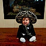 Lukah joined the competition — help win amazing prizes! baby, child, clothing, cute, face, fireplace, floor, formal_wear, happy, hat, headwear, indoors, infant, portrait, sitting, smile, sombrero, toddler, tuxedo, wood_floor