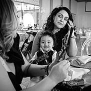 Lukah is registered to the contest to win money with this photo: black_and_white, candid, chair, child, dining, dress, event, fan, glass, hair, happy, indoor, jewelry, napkin, people, portrait, smile, table, toddler, woman