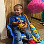 Jeffrey joined the competition — help win amazing prizes! baby_shark, balloons, blue_chair, blue_shirt, carpet, child, cornrows, cute, footwear, happy, indoor, jeans, paw_patrol_slippers, person, playful, smiling, toddler, toy_vacuum, wood_paneling, yellow_cup