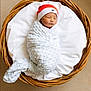 newborn, baby, swaddled, blanket, wicker_basket, hat, sleeping, infant, cozy, cushion, soft_texture, cute, resting, child, portrait, indoor, peaceful, headwear, person, wrapped