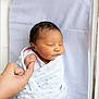 Messiah is registered to the contest to win money with this photo: newborn, baby, swaddled, blanket, hand, finger, hospital, bed, sleeping, infant, person, skin, cute, peaceful, closeup, family, tender, love, care, rest