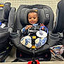 baby, car_seat, child, store, display, retail, product, smile, clothing, footwear, shelf, indoor, person, head, seat_belt, tag, happy, toy, shopping, infant