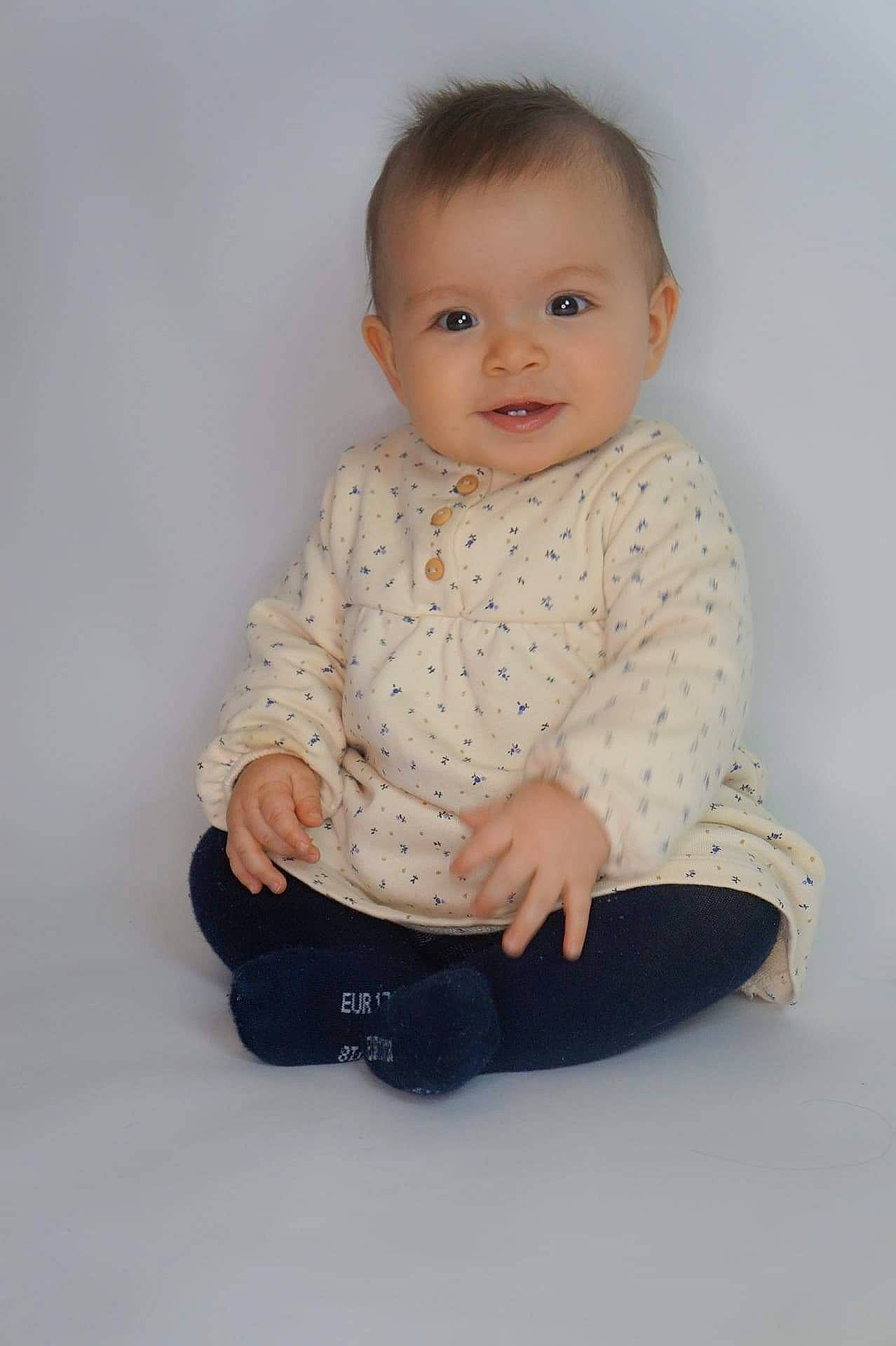 Lyna participe au concours pour gagner de l'argent avec cette photo : baby, baby_toddler_clothing, beige, cheek, child, child_model, comfort, eye, hand, iris, joint, joy, nose, organ, person, photo_shoot, shoe, sitting, skin, sleeve