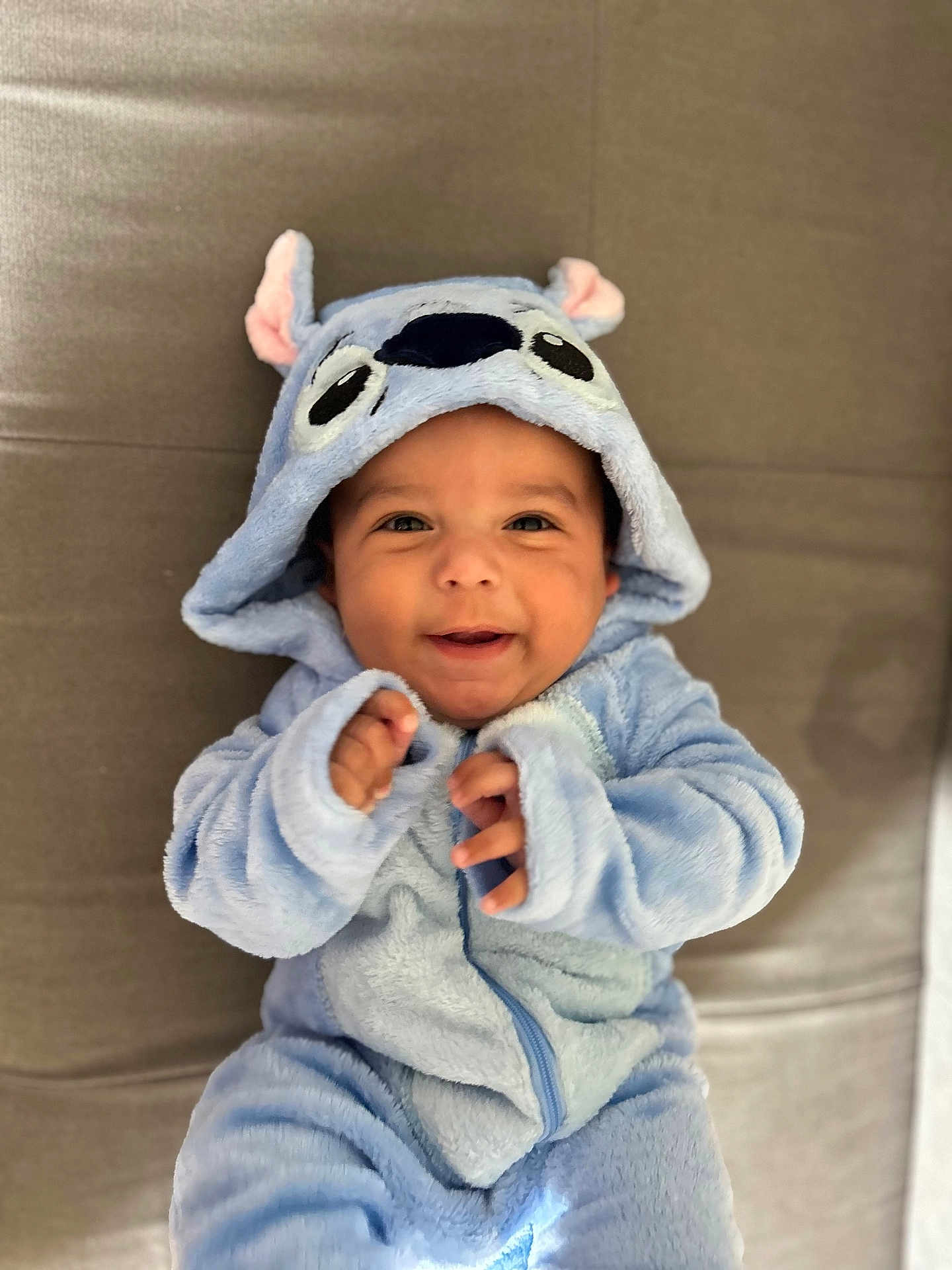 Warren participe au concours pour gagner de l'argent avec cette photo : baby, child, smile, blue_onesie, hood, cute, infant, happy, soft_texture, animal_costume, face, portrait, lying_down, clothing, cozy, warm, indoors, person, baby_garment, cute_expression