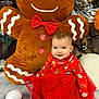 baby, child, tutu, red_clothing, gingerbread_man, plush_toy, holiday, christmas, festive, smile, winter, snow, background, sitting, cute, indoor, toy, red_bow, decorations, happy