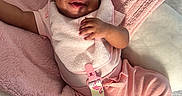 Kehlani joined the competition — help win amazing prizes! baby, smiling, pink_clothing, blanket, pacifier, curly_hair, infant, cute, happy, soft_texture, lying_down, indoor, child, cozy, headband, playful, sunlight, person, toddler, closeup