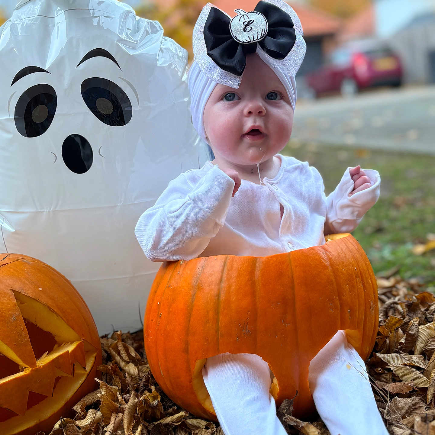 Elsie is registered to the contest to win money with this photo: autumn, baby, bow, child, cute, drool, fall, festive, ghost_balloon, halloween, headband, holiday, jack_o_lantern, leaves, outdoor, portrait, pumpkin, seasonal, sitting, white_clothing