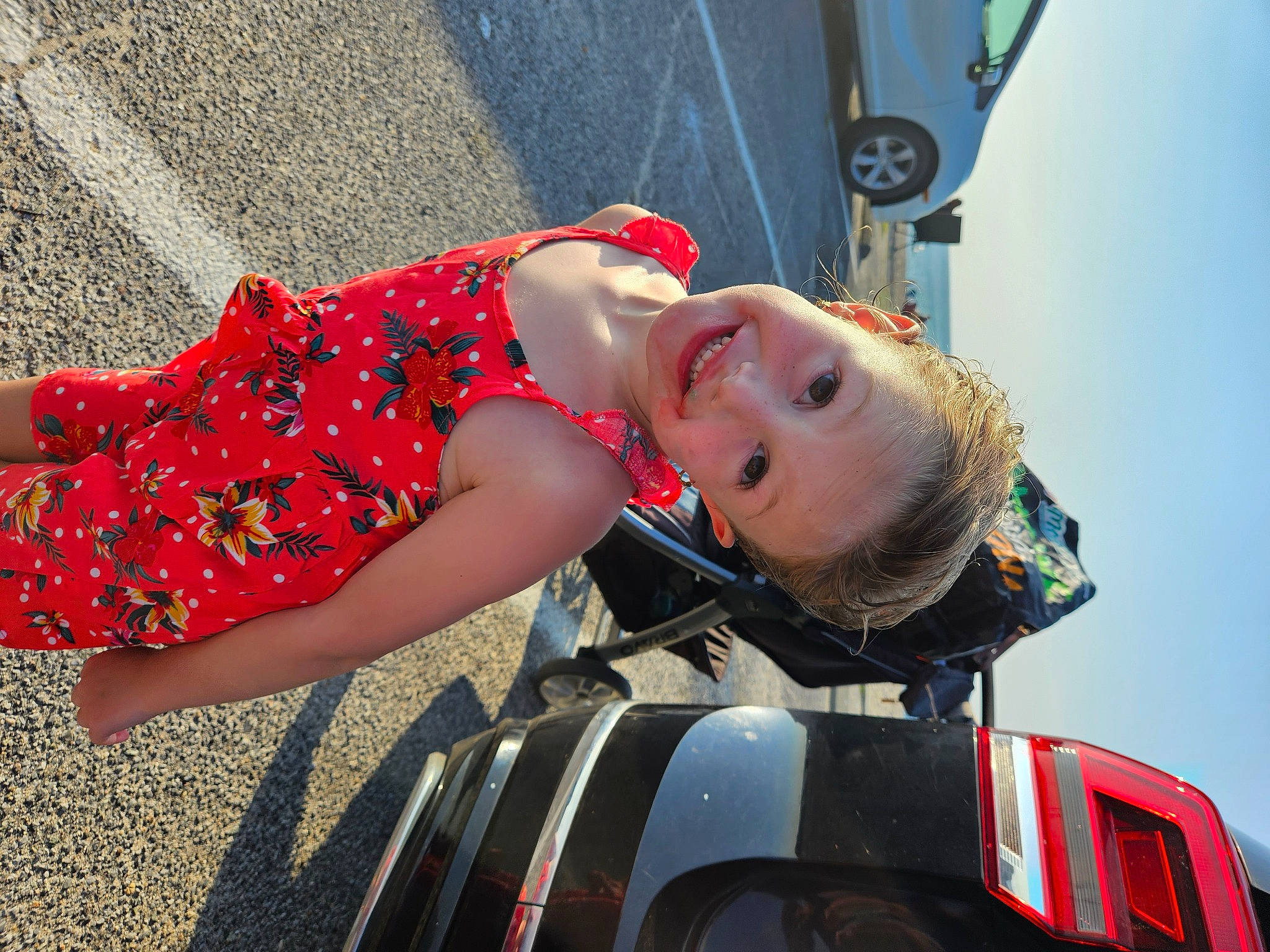 Madelyn is registered to the contest to win money with this photo: asphalt, automotive_design, automotive_exterior, automotive_lighting, automotive_tire, automotive_wheel_system, bumper, car, human_body, human_leg, joy, motor_vehicle, person, sky, smile, thigh, tire, toddler, travel, vehicle_door