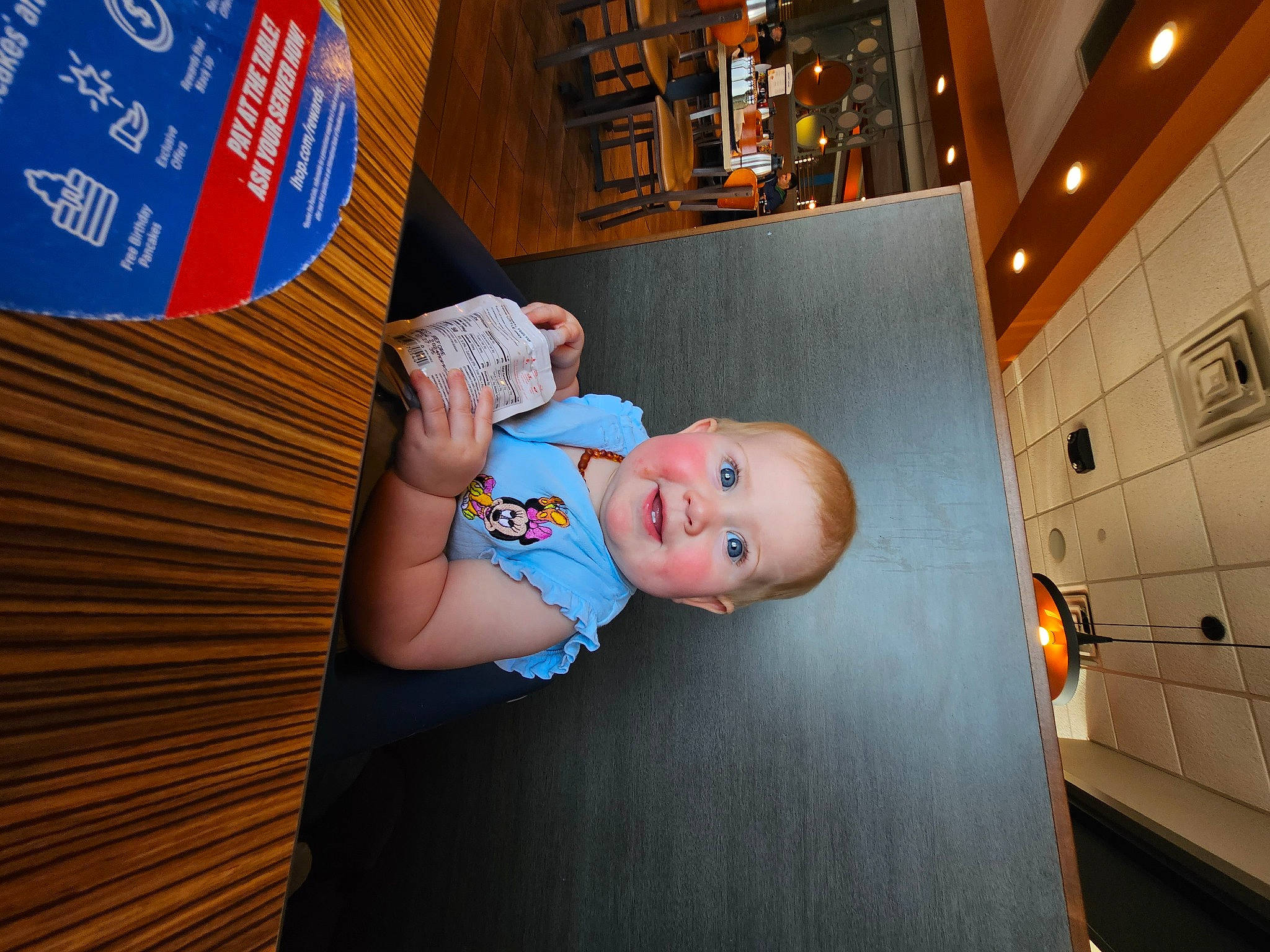 Maisie is registered to the contest to win money with this photo: advertising, art, baby, baby_toddler_clothing, child, flash_photography, flooring, fun, hat, joy, leisure, orange, person, room, space, standing, t_shirt, toddler, wood