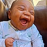baby, laughing, happy, infant, onesie, dinosaur_print, chair, porch, car, outdoor, furniture, smile, cute, child, person, closeup, joy, expression, casual, relaxed