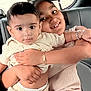 Varun is registered to the contest to win money with this photo: child, baby, siblings, car_seat, smile, hug, bracelet, clothing, portrait, indoor, family, person, cute, toddler, affection, happy, seat, window, hair, face