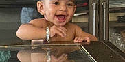Varun is registered to the contest to win money with this photo: toddler, child, smiling, happy, bracelet, reflection, glass, table, indoors, furniture, face, hand, expression, cute, young, person, portrait, joyful, baby, cheerful