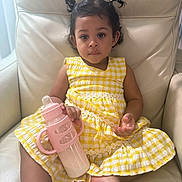 Camilla joined the competition — help win amazing prizes! toddler, child, baby_bottle, yellow_dress, pigtails, indoor, chair, leather, milk, seated, portrait, cute, calm, person, clothing, furniture, skin, hair, hand, foot
